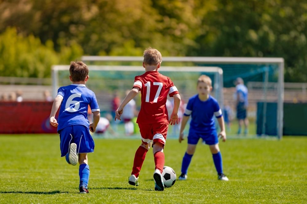 Red soccer player dribbling the ball