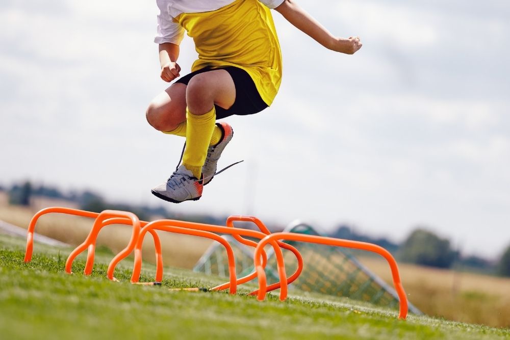 Soccer player practicing with hurdle hops