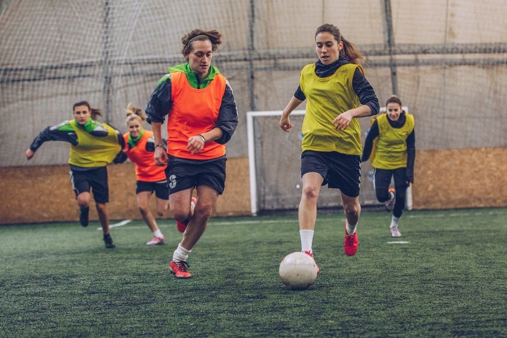 female soccer players running fast for a soccer ball