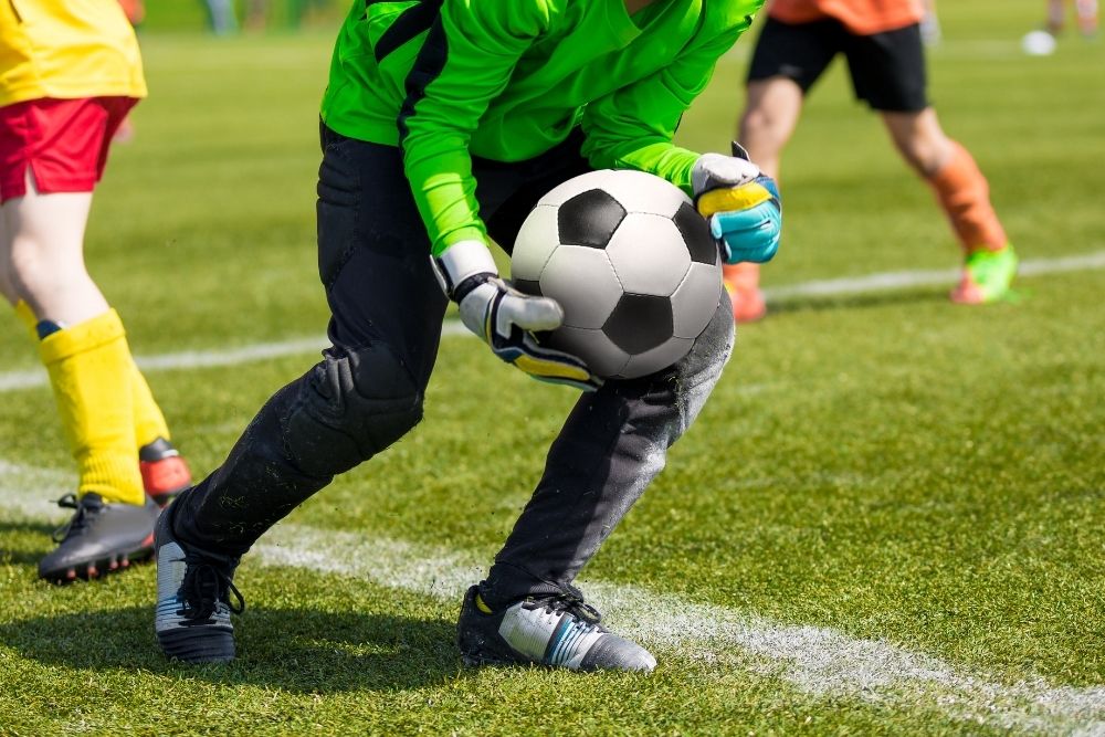 goalkeeper holding soccer ball