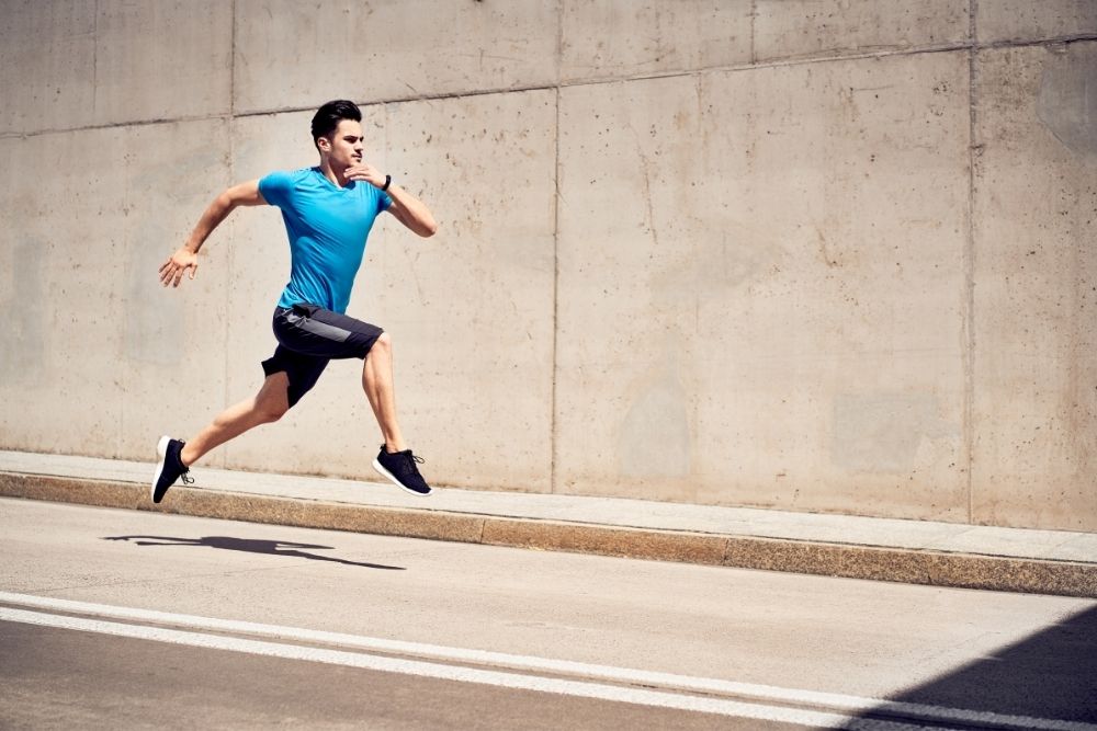 man in blue t shirt doing sprinting on the street
