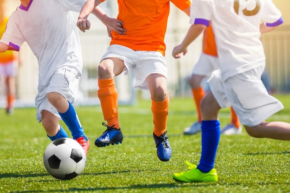 Orange soccer player facing the white opponent in soccer