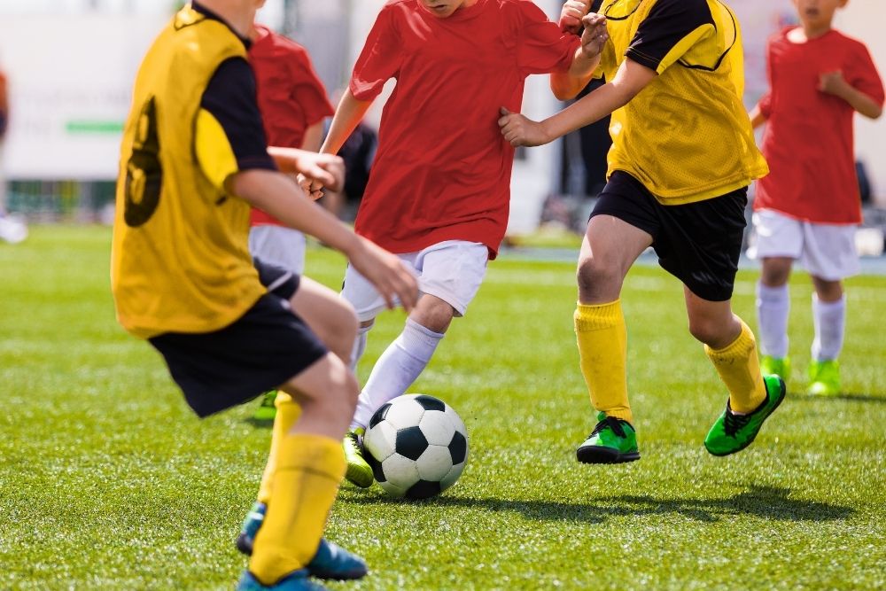 Red soccer player facing yellow opponents