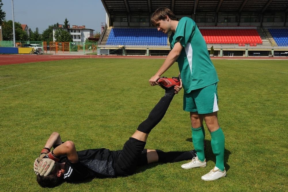 stretching a leg of goalie to cure cramping