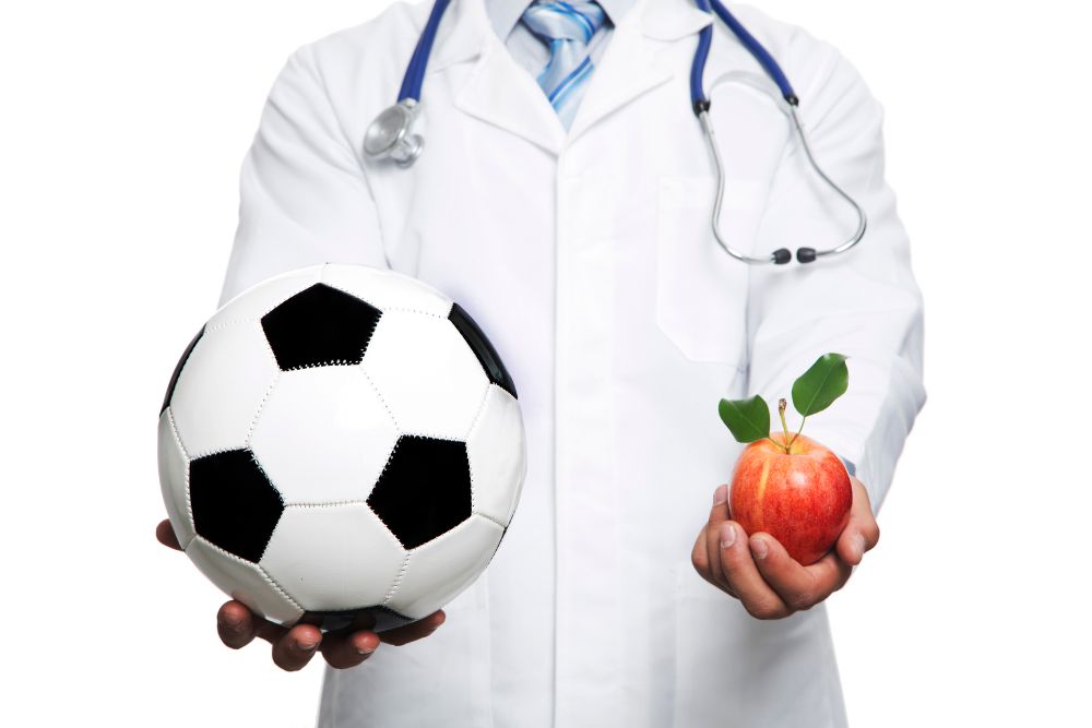 Doctor are holding the soccer ball and an apple