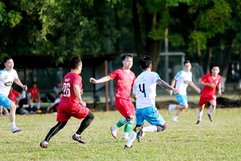 Red soccer player trying to driblle through the opponents