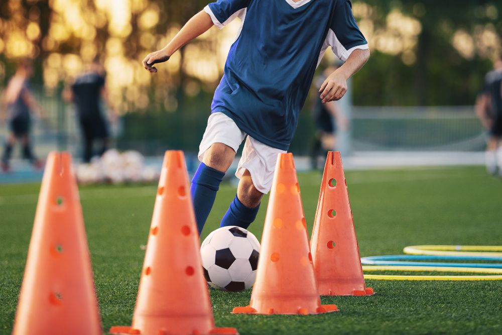 Soccer player is practicing with cones