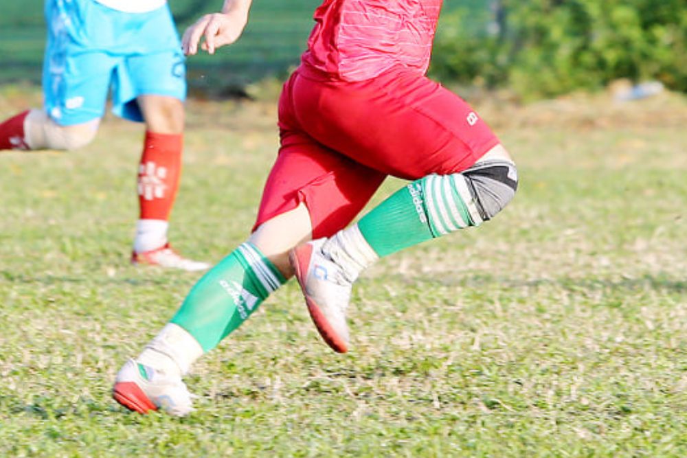 Soccer player wearing knee brace run on the field