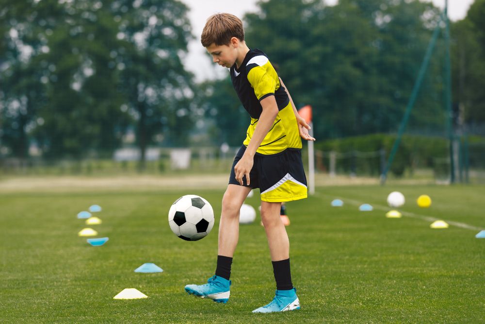 Young soccer player are juggling the ball on the field