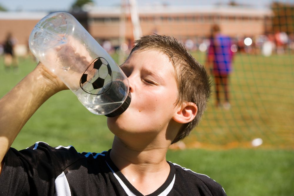 Young soccer player is drinking water