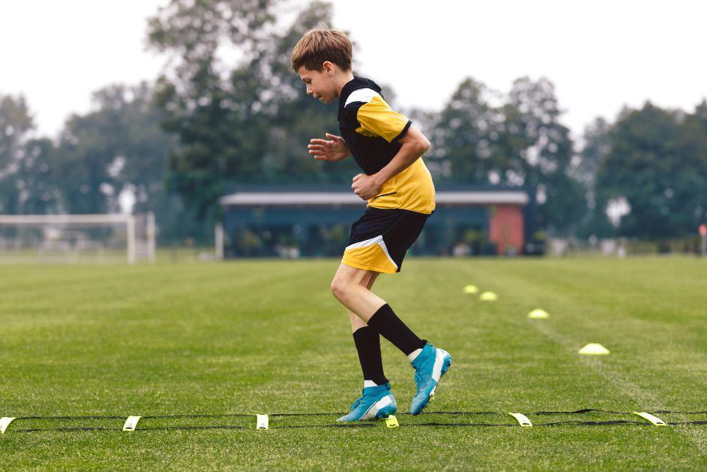 Young soccer player is focusing on the ladder drills