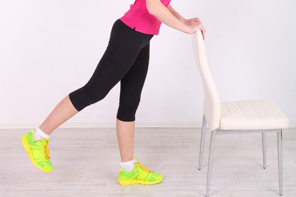 a girl does exercises with a chair