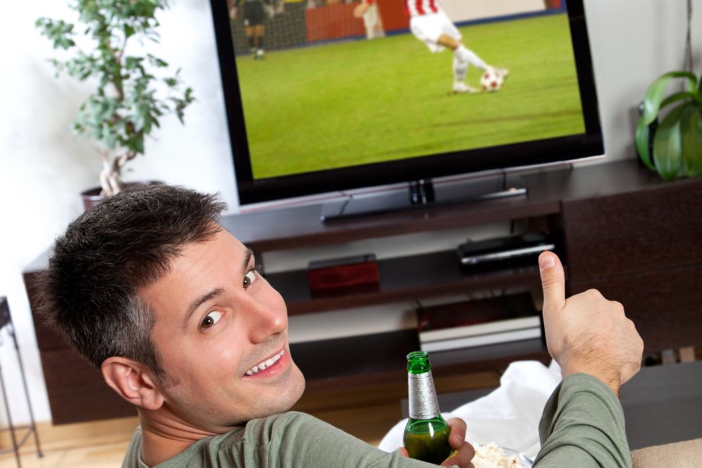 man watches soccer on TV to learn some skills