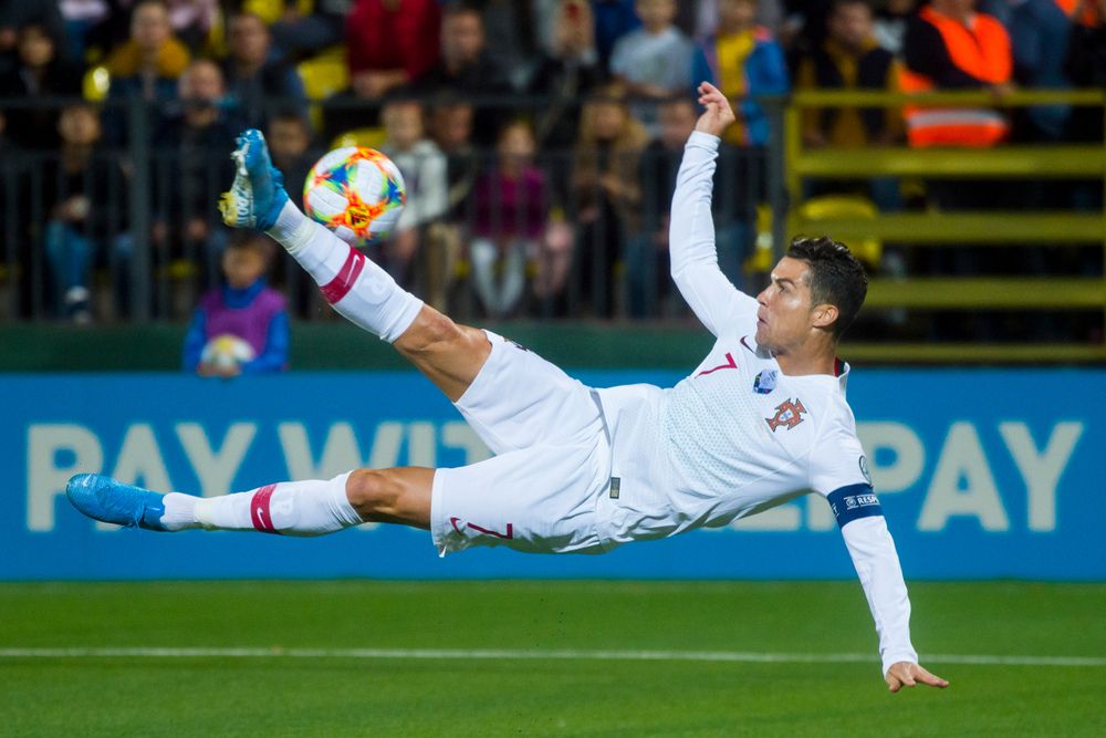 Ronaldo are trying to kick the soccer ball