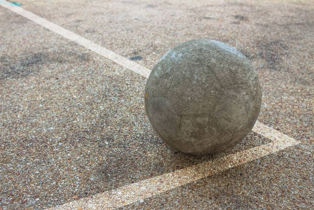 worn soccer ball in the concrete
