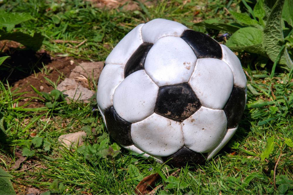 underinflated soccer ball on the ground